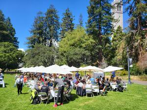 Photo of One IT picnic with tables of people in the foreground and the campanile in the background