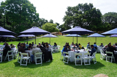 Employees sitting at tables at the annual One IT Picnic on the Faculty Club Glade at UC Berkeley